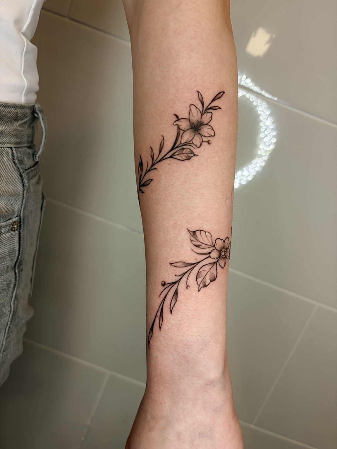 Zwei feine florale Tattoos am Arm